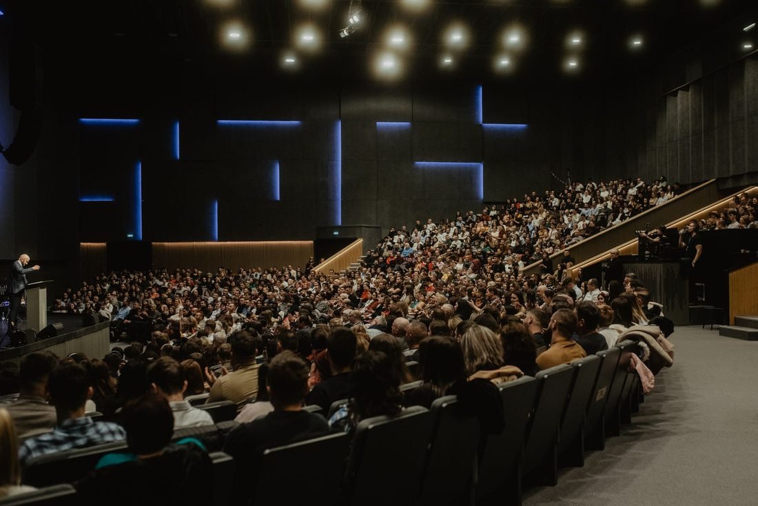 Delegates seated in a large conference auditorium
