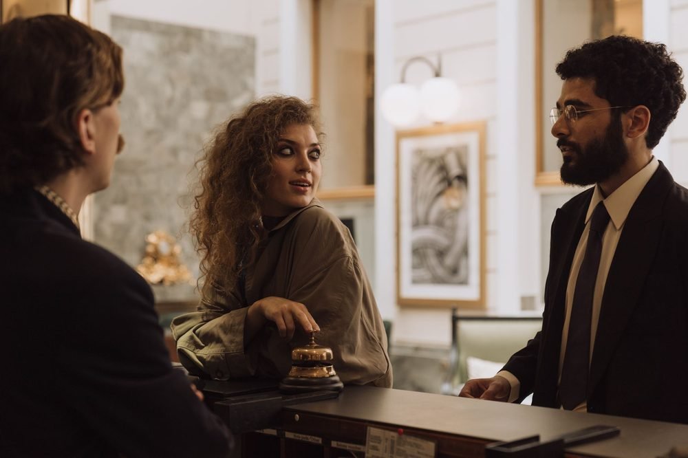 Guest relations executive assisting travellers at a hotel desk
