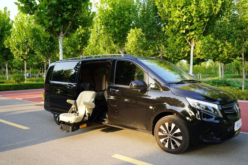 Black Mercedes luxury van with sliding door open, ready for a group transfer