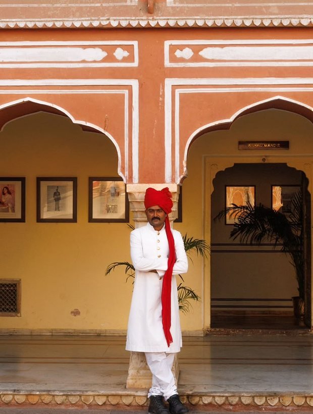 Darban in a white achkan and red safa at the arcade of a Rajasthan palace